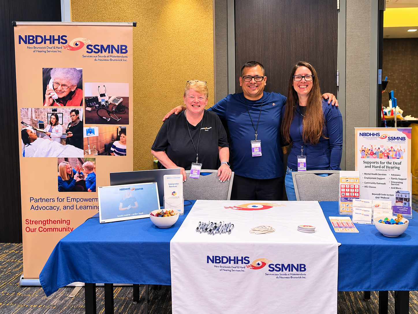 NBDHHS staff at a community event booth promoting services for Deaf and hard of hearing individuals