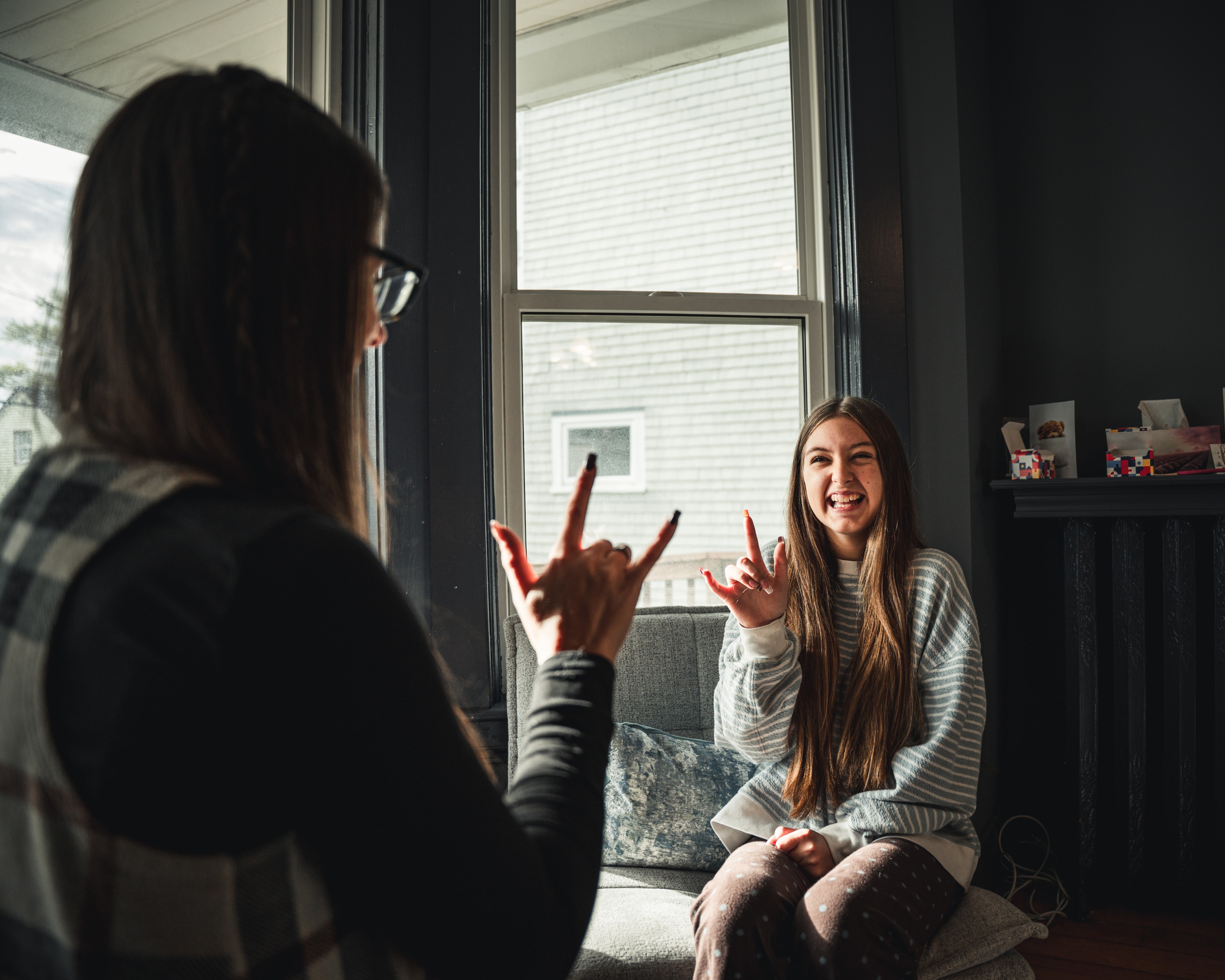 Two people sharing a warm moment by a window, representing family support
